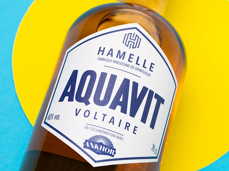 Bouteille d’aquavit en gros plan sur fond jaune et bleu